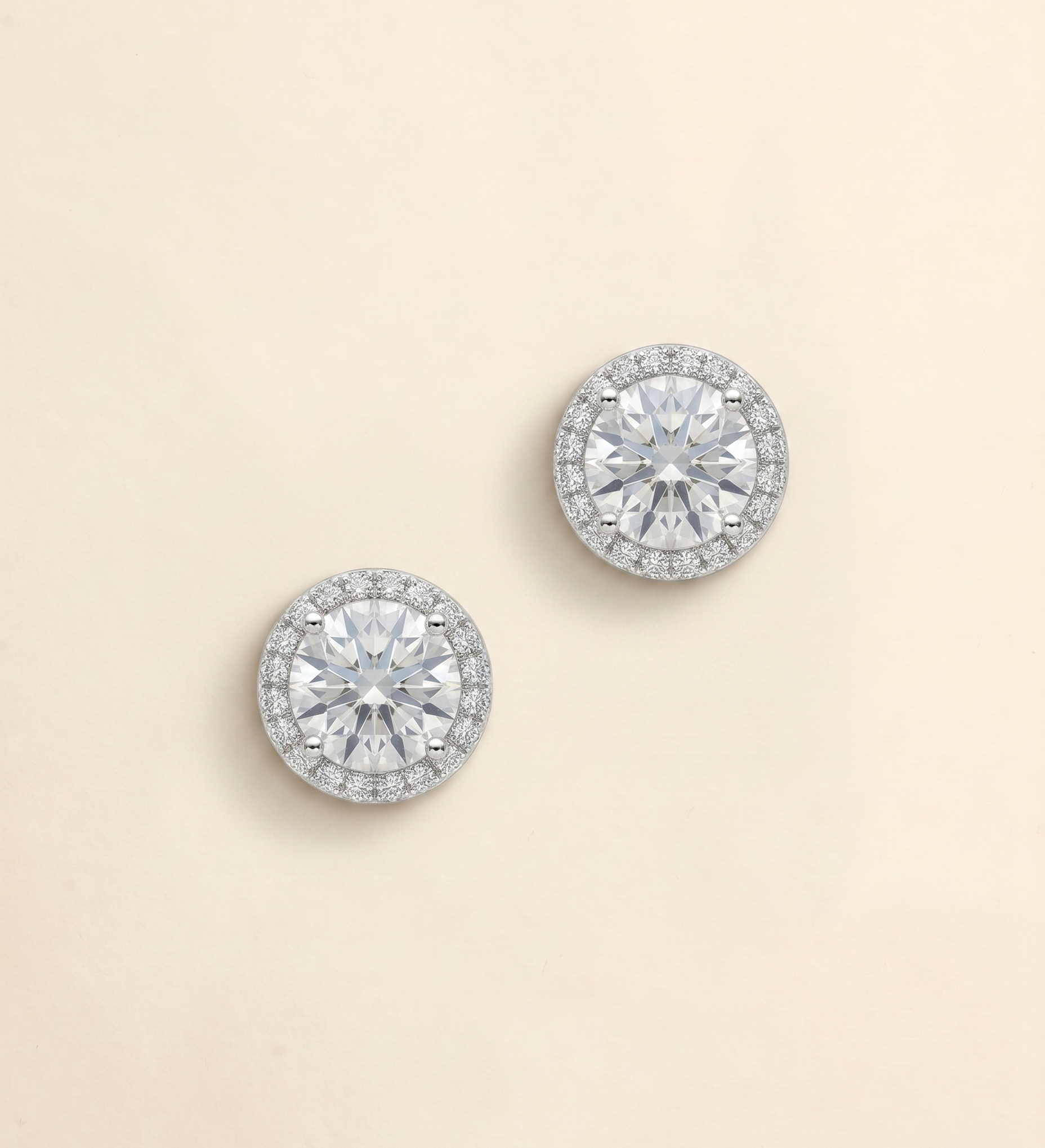 A pair of elegant diamond earrings with a large central diamond surrounded by smaller diamonds, set in a halo of smaller diamonds.