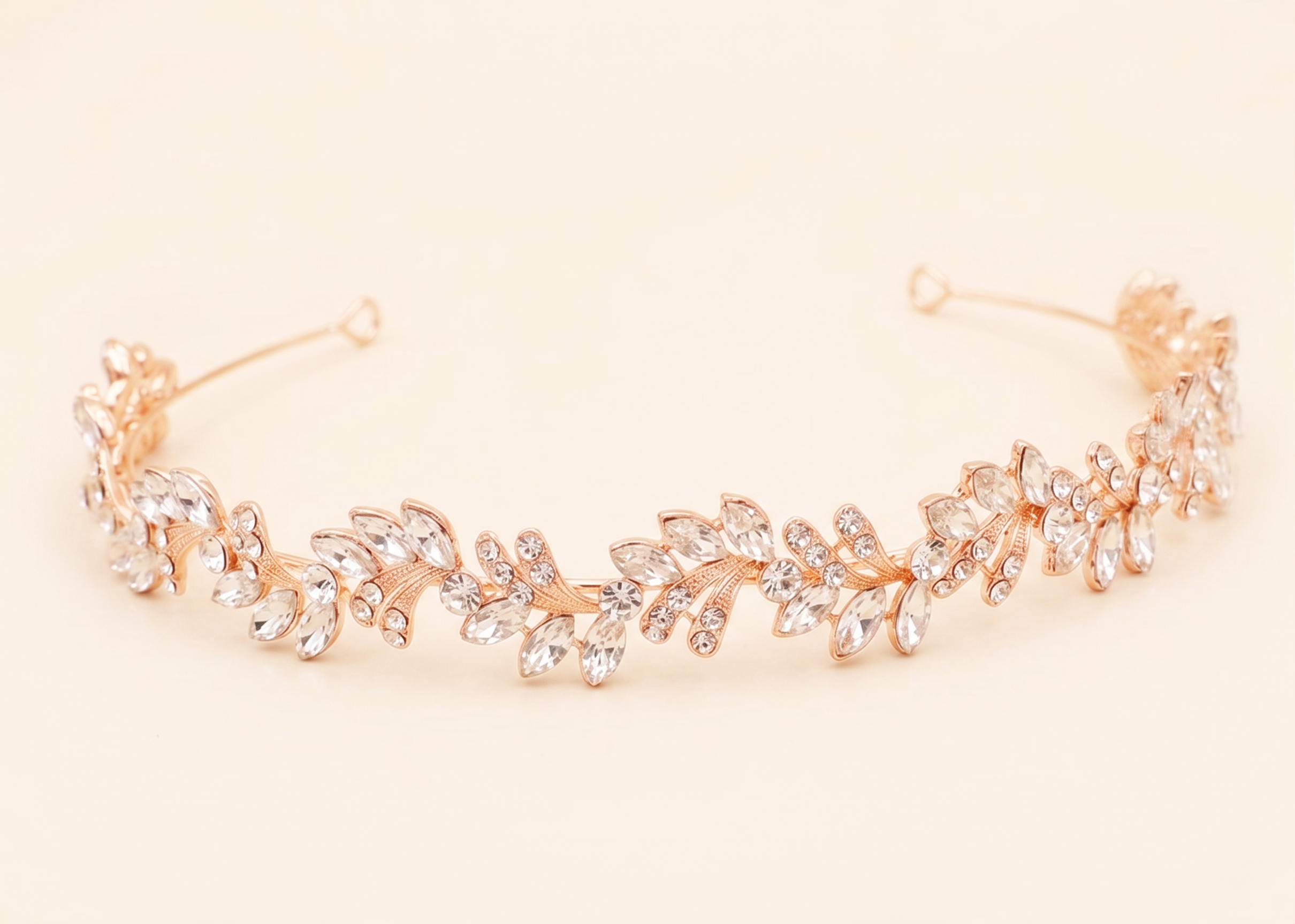 A gold-colored tiara adorned with numerous small, clear gemstones arranged in a decorative pattern.