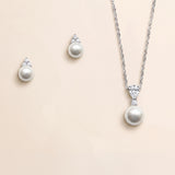 A necklace and earrings set made of silver and white pearls, with a pendant featuring a large round pearl and smaller pearls.