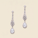 A pair of elegant diamond earrings with intricate designs and dangling crystal stones.
