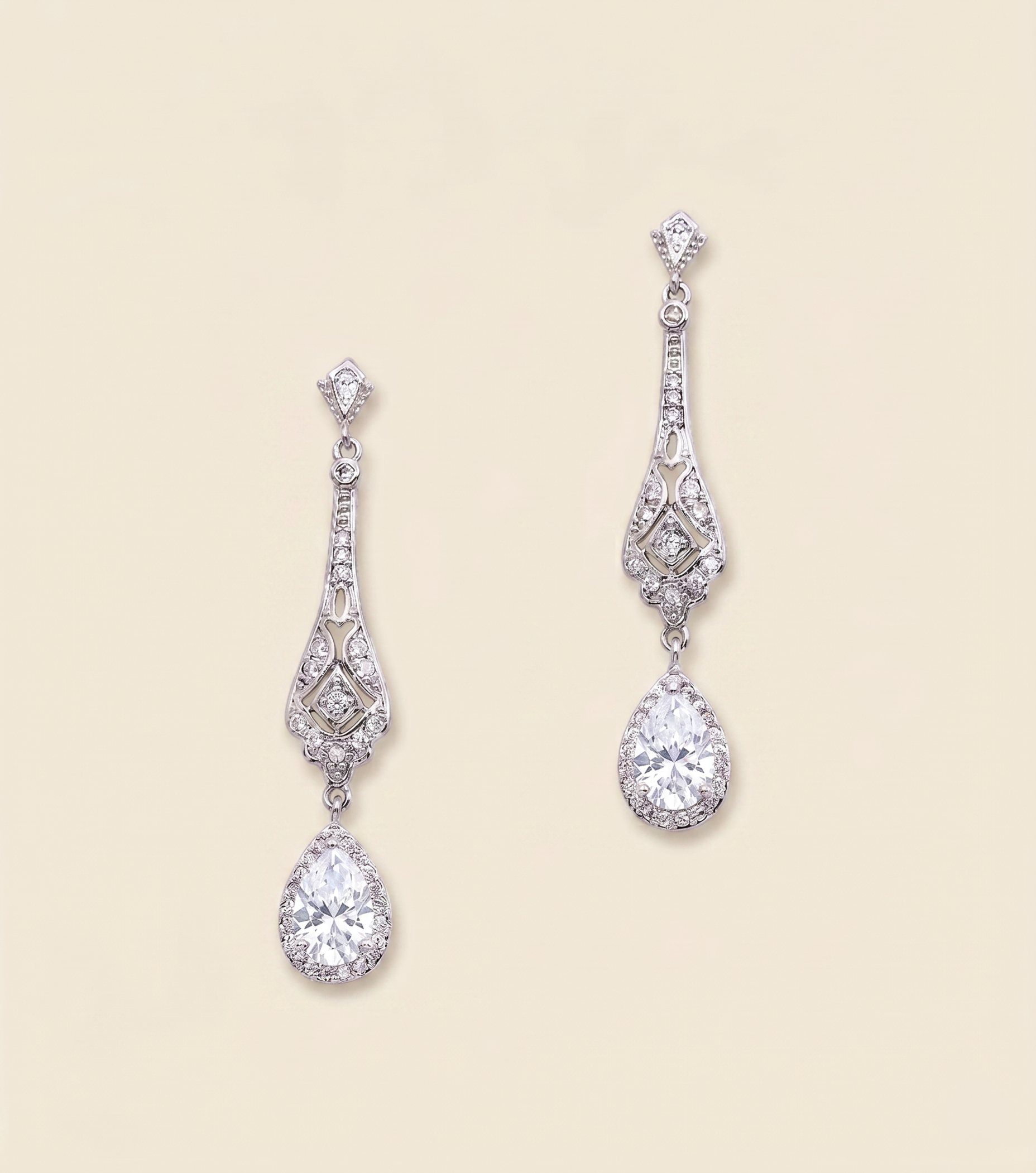 A pair of elegant diamond earrings with intricate designs and dangling crystal stones.