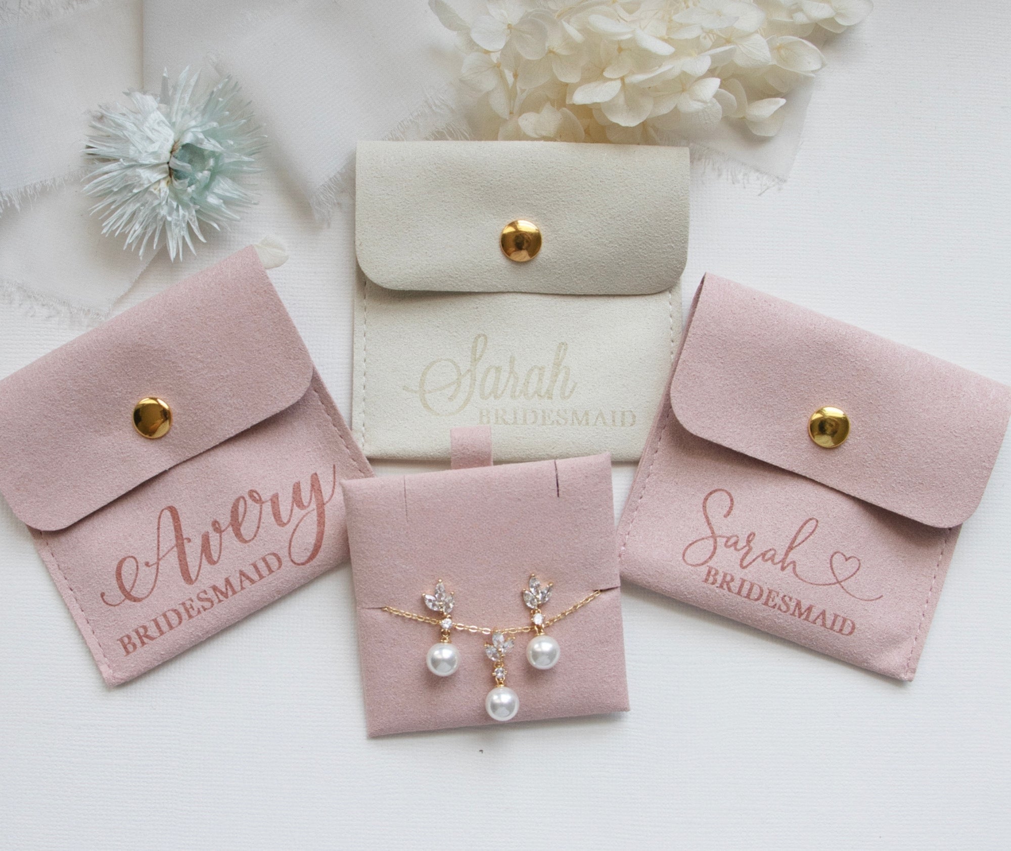 a collection of jewelry and accessories, including earrings, a necklace, and a bridesmaid's bag, all arranged on a white background.