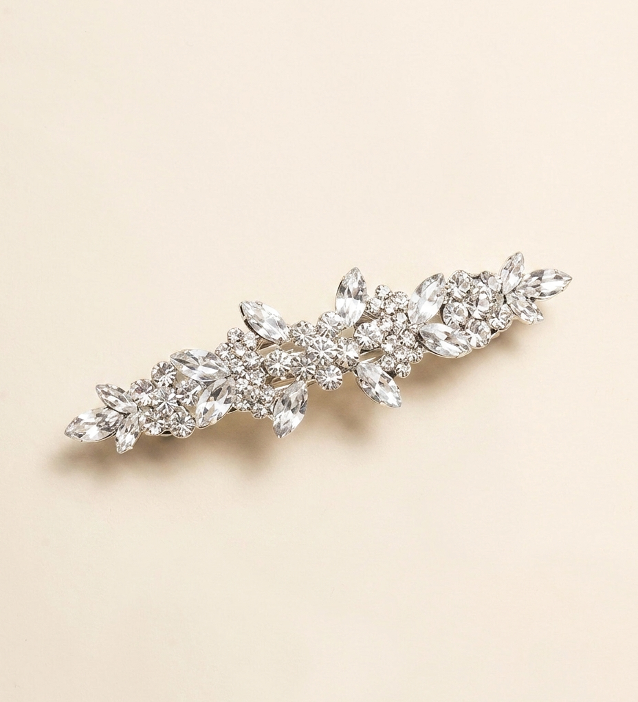 A decorative hair clip with a floral design and sparkling crystal elements.