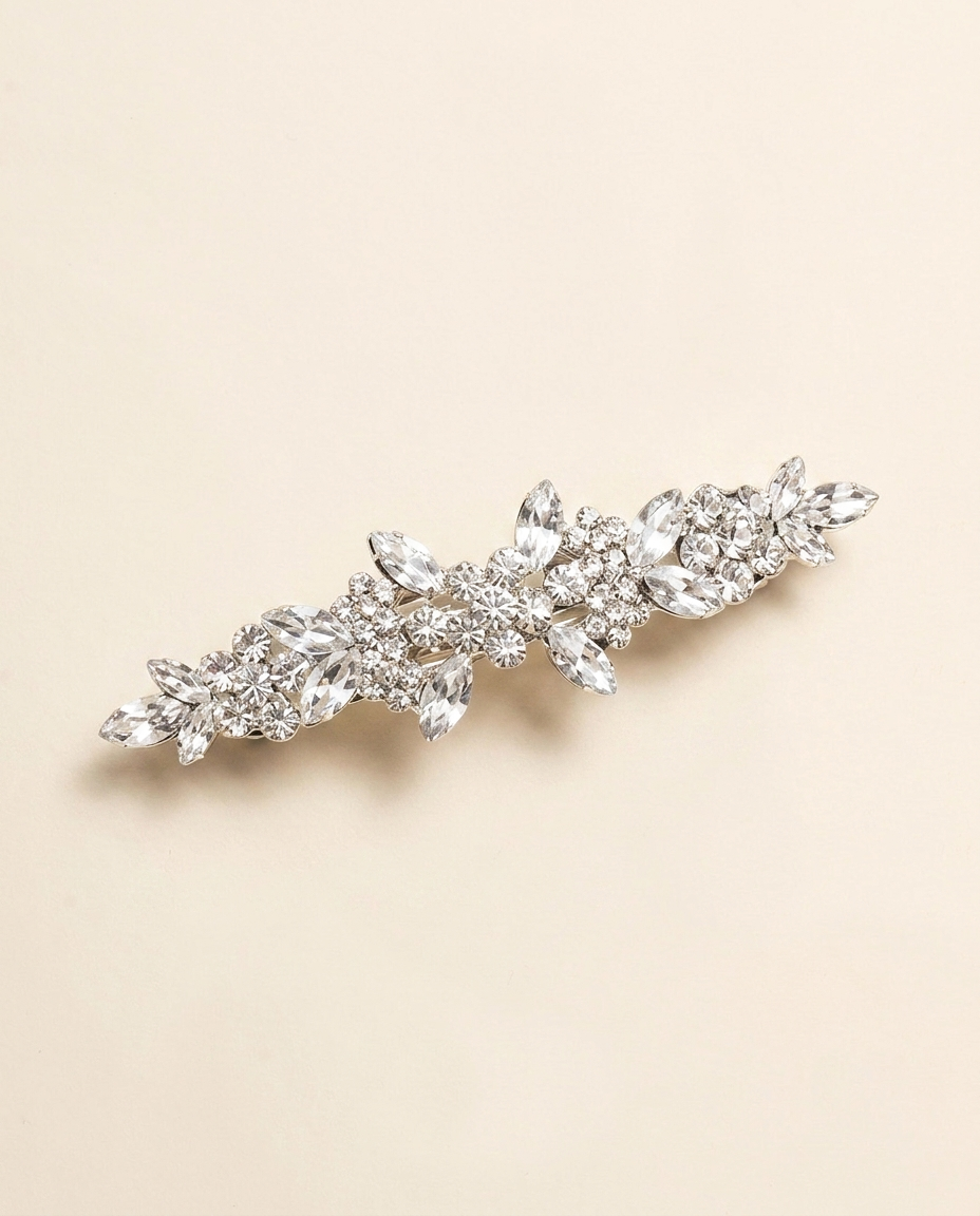 A decorative hair clip with a floral design and sparkling crystal elements.
