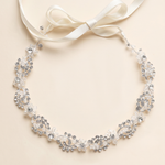 A delicate necklace with a white ribbon and a floral design, featuring small, sparkling crystals.