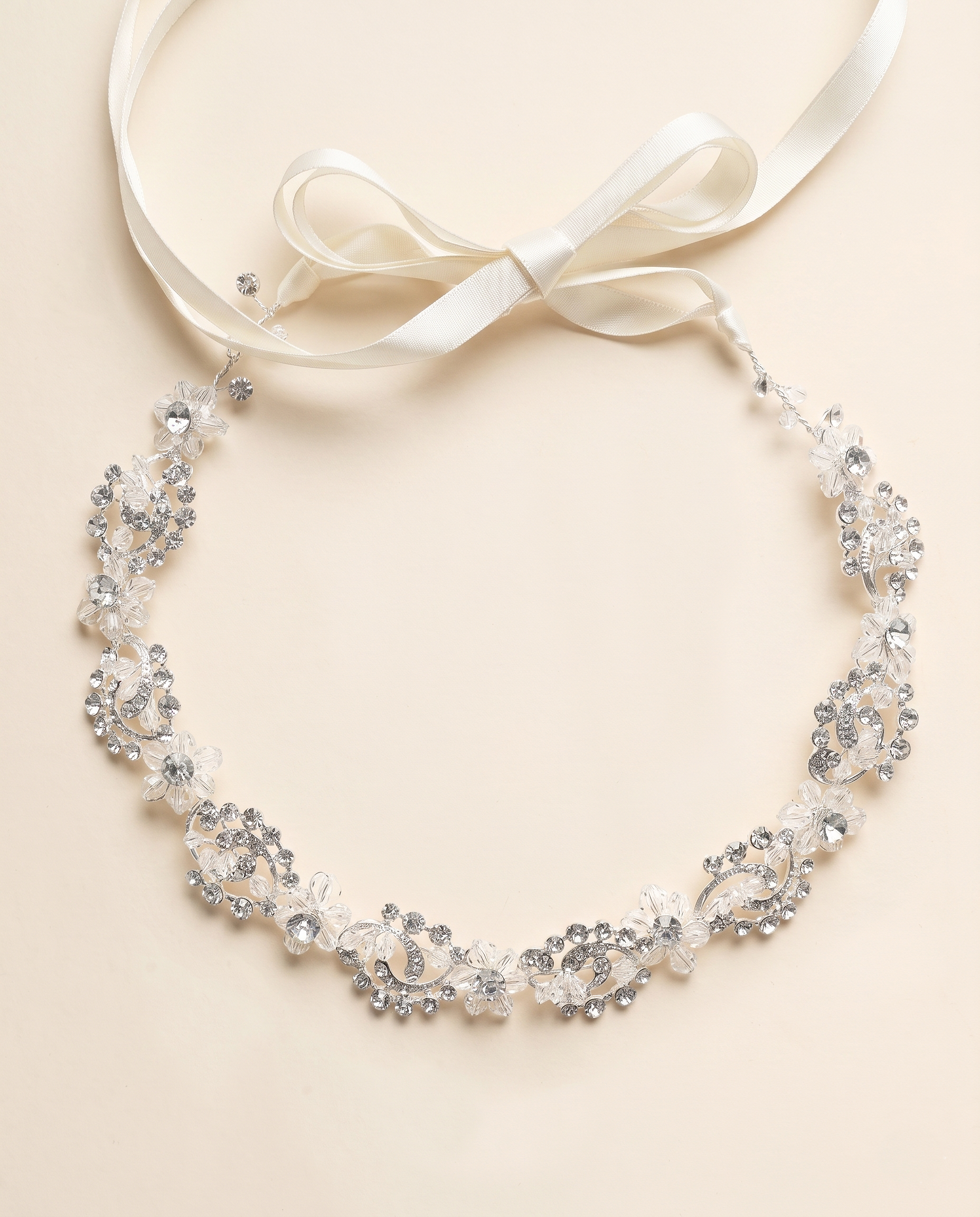 A delicate necklace with a white ribbon and a floral design, featuring small, sparkling crystals.