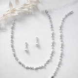a collection of elegant jewelry pieces, including a necklace, earrings, and a bracelet, all adorned with sparkling diamonds and pearls.