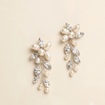 A pair of elegant earrings with a combination of pearls, crystals, and flowers.