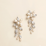 A pair of elegant earrings with a combination of pearls, crystals, and flowers.