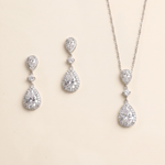 A necklace and earrings set made of silver and crystal materials, featuring large, clear gemstones.