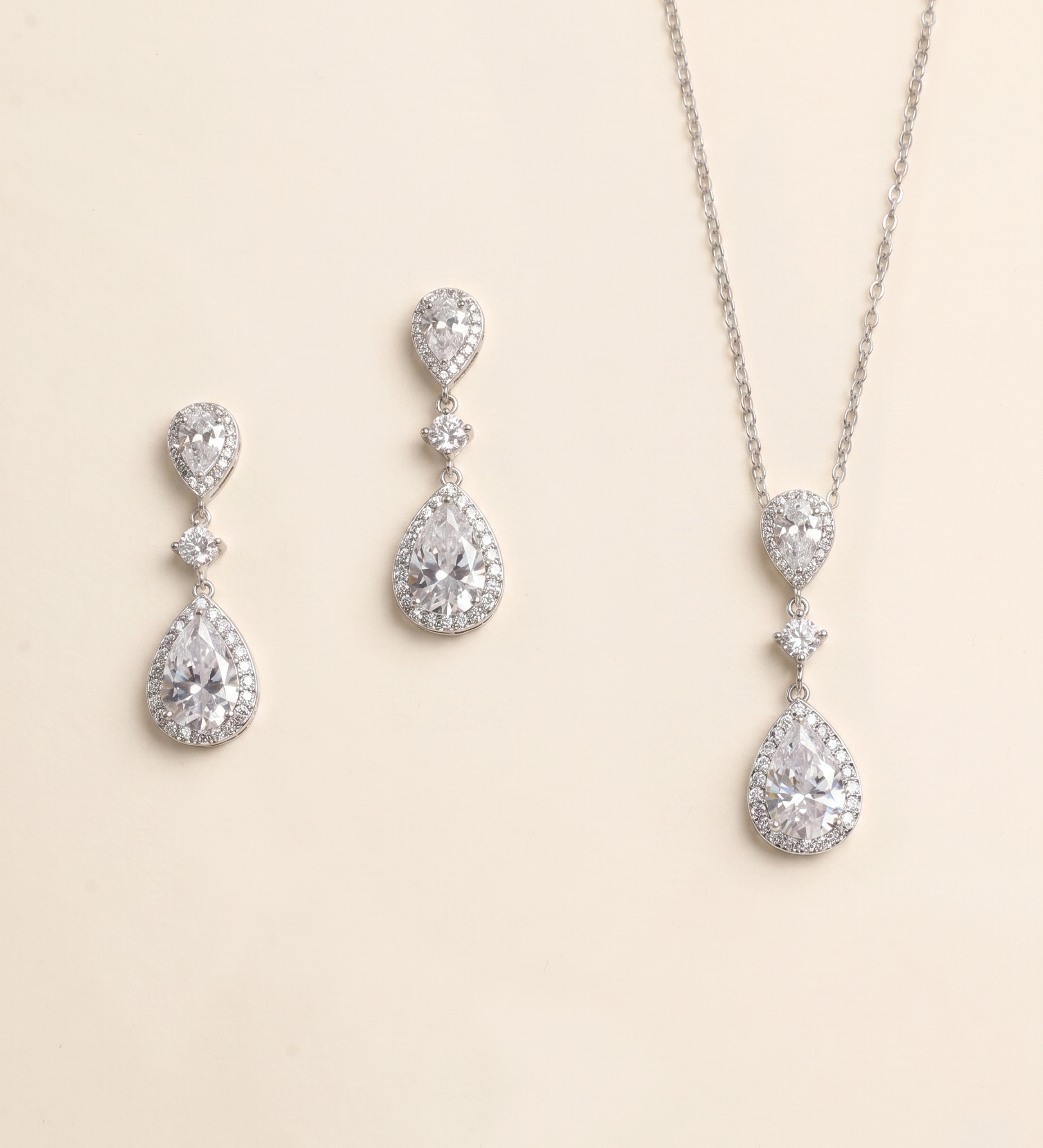 A necklace and earrings set made of silver and crystal materials, featuring large, clear gemstones.