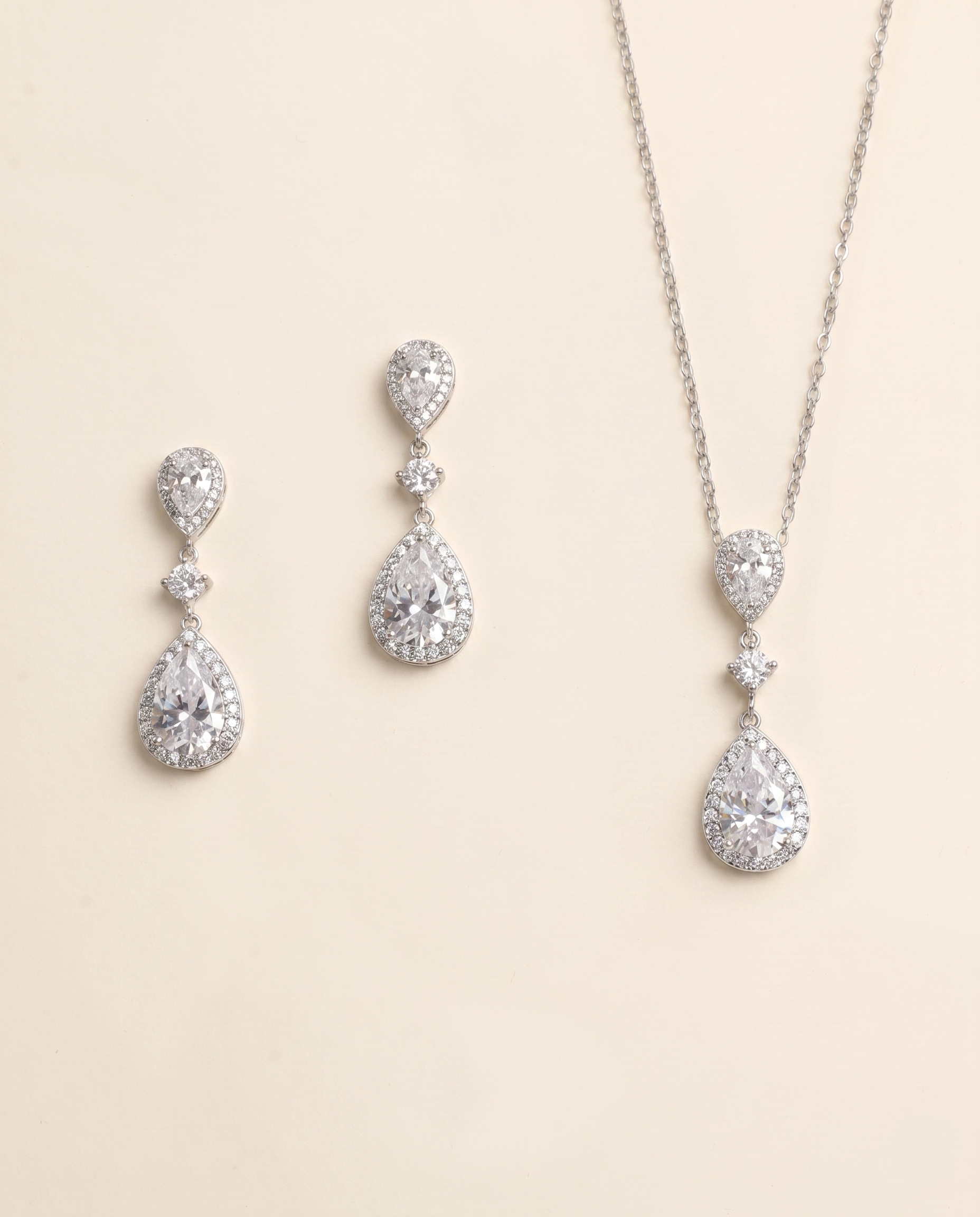 A necklace and earrings set made of silver and crystal materials, featuring large, clear gemstones.