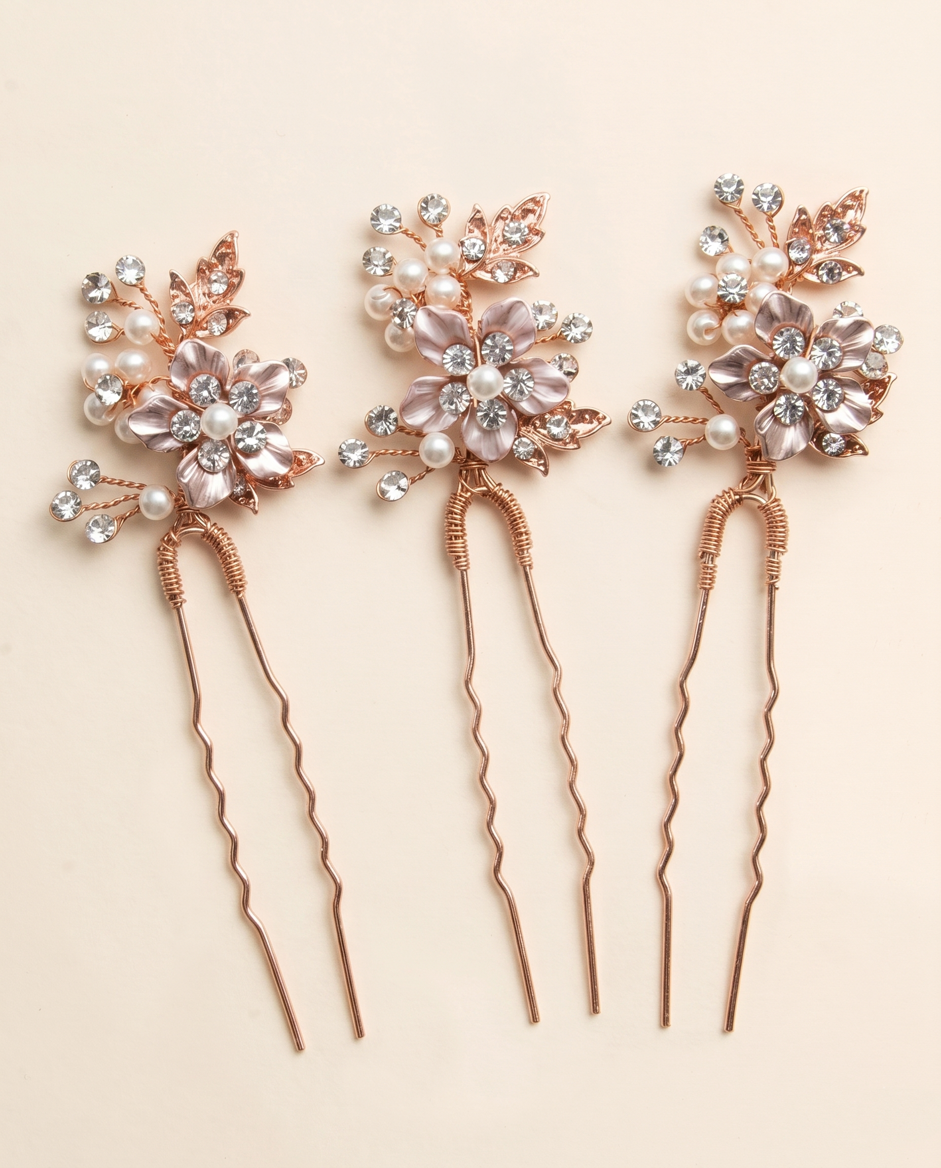 a set of three decorative hair clips with floral designs and sparkling gemstones.