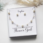 A gift box containing a necklace and earrings, with a personalized message on the box.