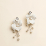 A pair of elegant white flower-shaped earrings with pearls and crystals.