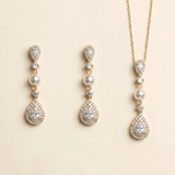 A set of elegant gold jewelry pieces, including earrings and a necklace, adorned with pearls and diamonds.