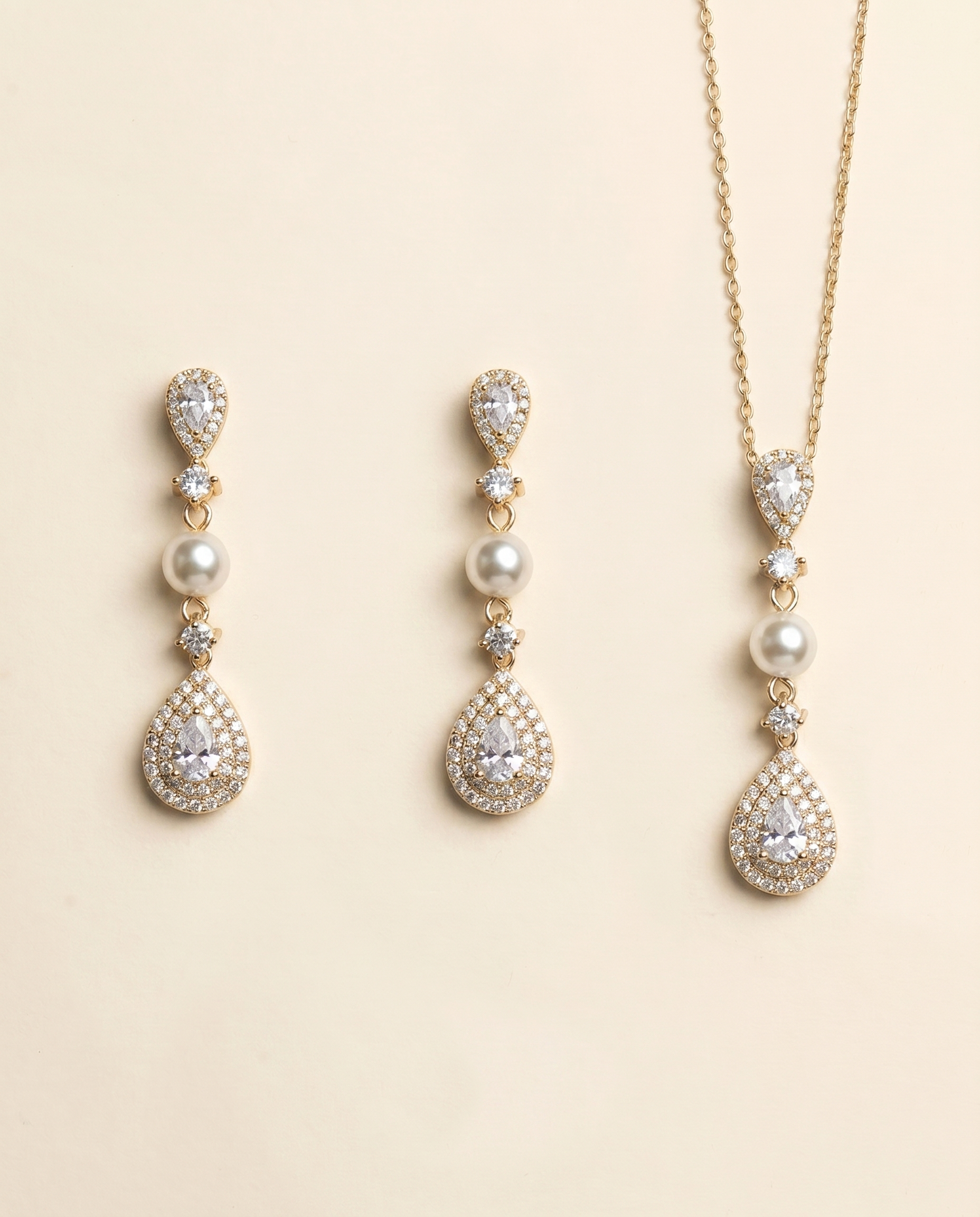 A set of elegant gold jewelry pieces, including earrings and a necklace, adorned with pearls and diamonds.