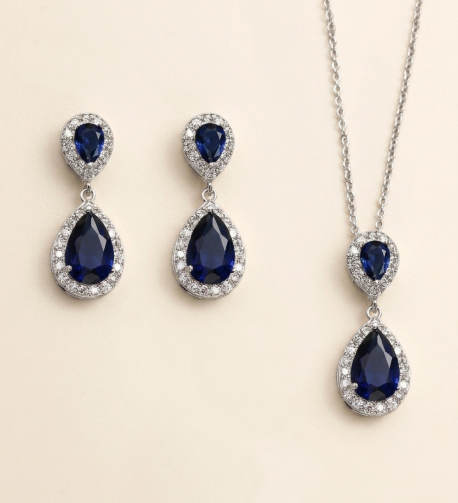 A pair of elegant earrings and a necklace featuring a combination of blue gemstones and sparkling diamonds.