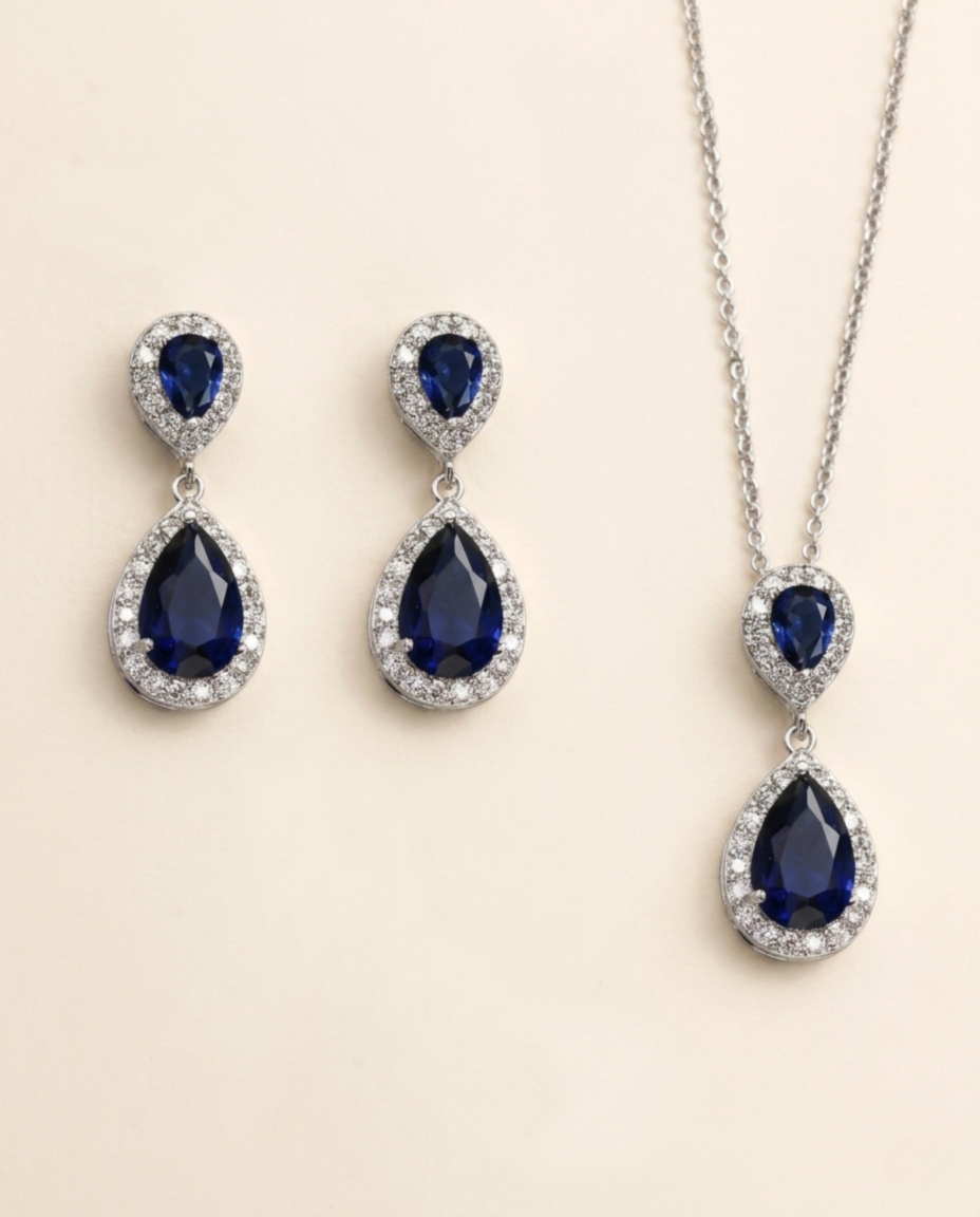 A pair of elegant earrings and a necklace featuring a combination of blue gemstones and sparkling diamonds.