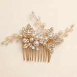 A decorative gold hairbrush adorned with pearls, crystals, and leaves.