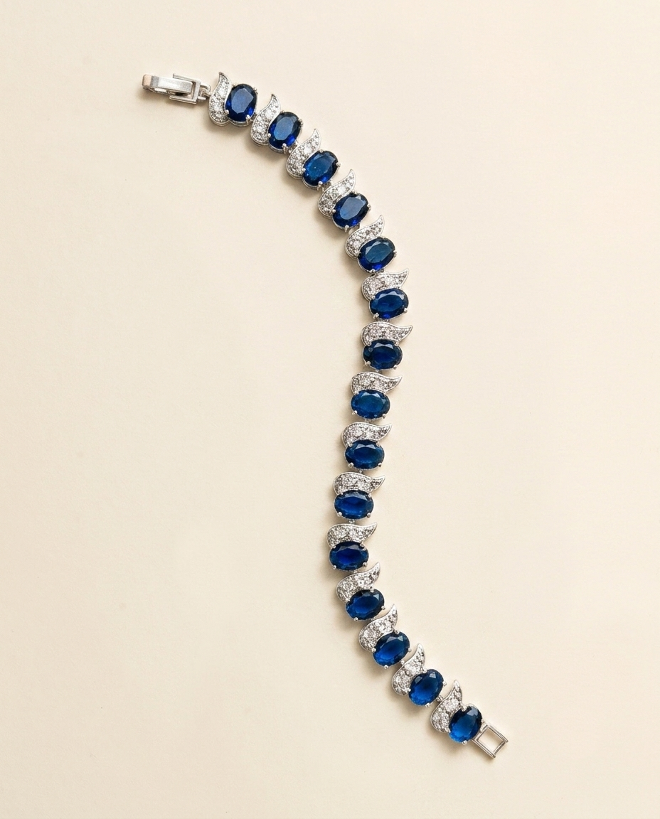 A bracelet with a row of blue gemstones, including diamonds, arranged in a decorative pattern.