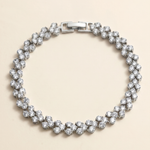 A silver bracelet adorned with numerous sparkling diamonds arranged in a circular pattern.