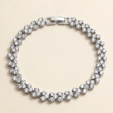 A silver bracelet adorned with numerous sparkling diamonds arranged in a circular pattern.