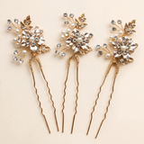 Three ornate hair pins with gold and crystal embellishments, arranged in a row.