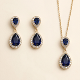A set of elegant jewelry pieces, including earrings and a necklace, featuring large blue gemstones and sparkling diamonds.