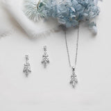 a necklace and earrings with a floral design, placed on a white background.