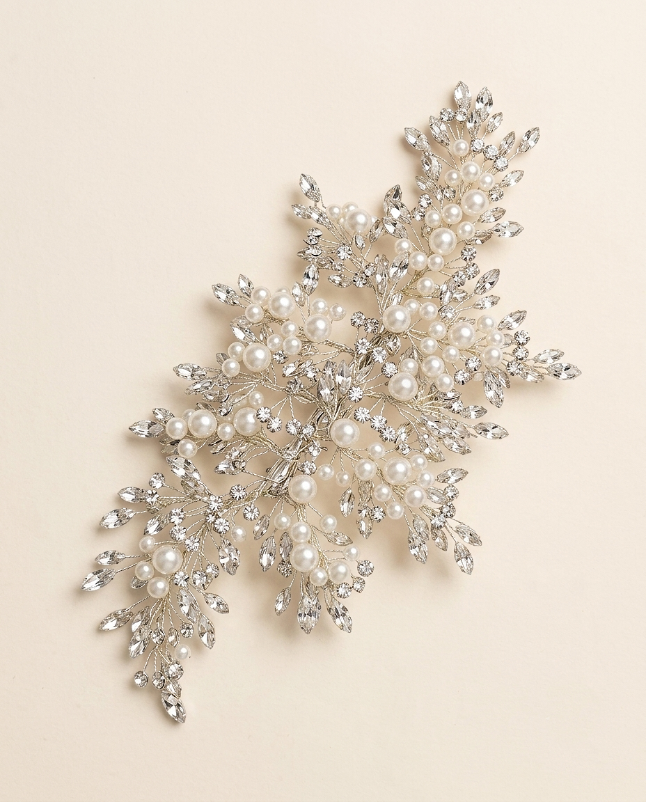 a decorative piece of jewelry with a combination of pearls and crystals, including a branch-like design with numerous small pearls and sparkling crystals.