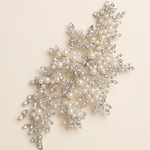 a decorative piece of jewelry with a combination of pearls and crystals, including a branch-like design with numerous small pearls and sparkling crystals.
