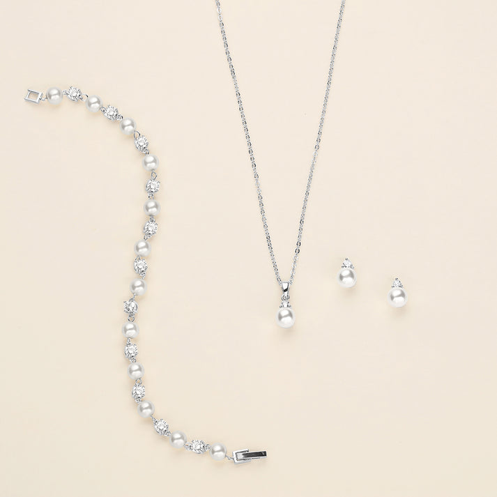 a necklace, earrings, and bracelet on a white surface