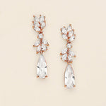 A pair of elegant earrings with clear gemstones and a delicate floral design.