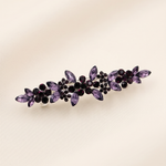 A decorative hair clip adorned with purple gemstones.