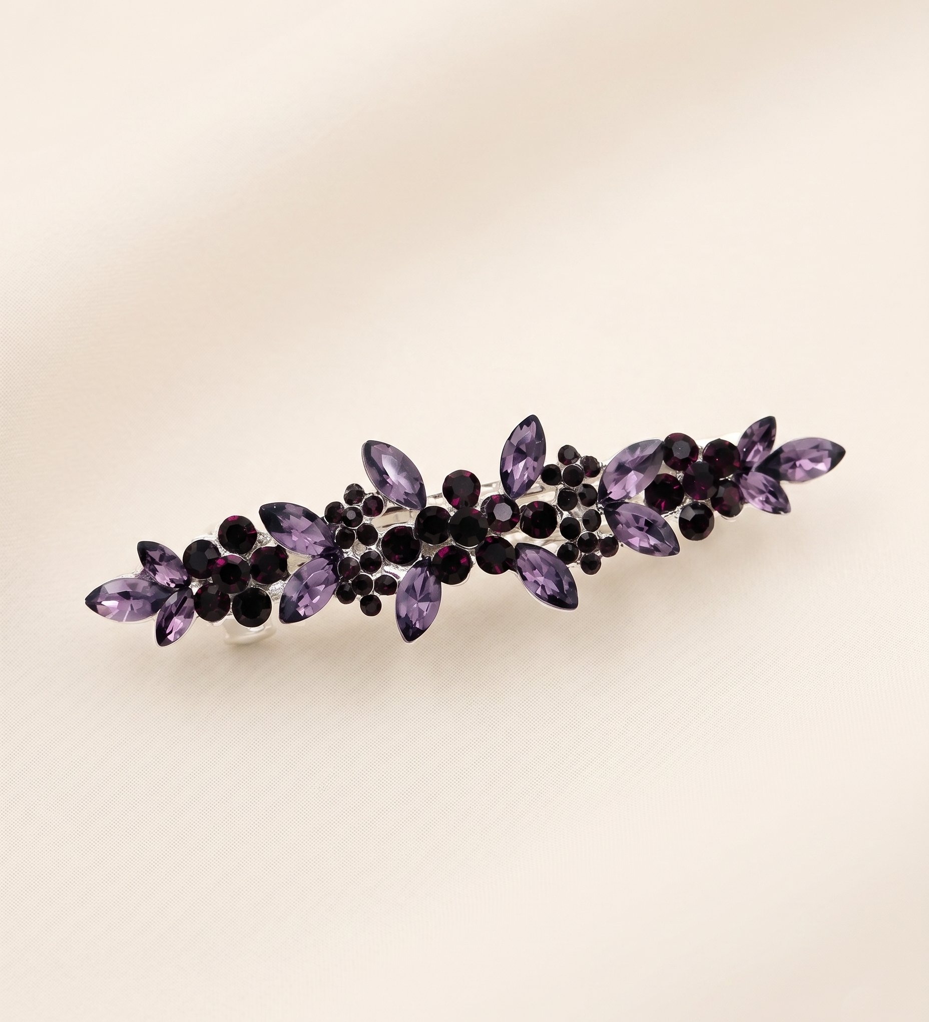 A decorative hair clip adorned with purple gemstones.