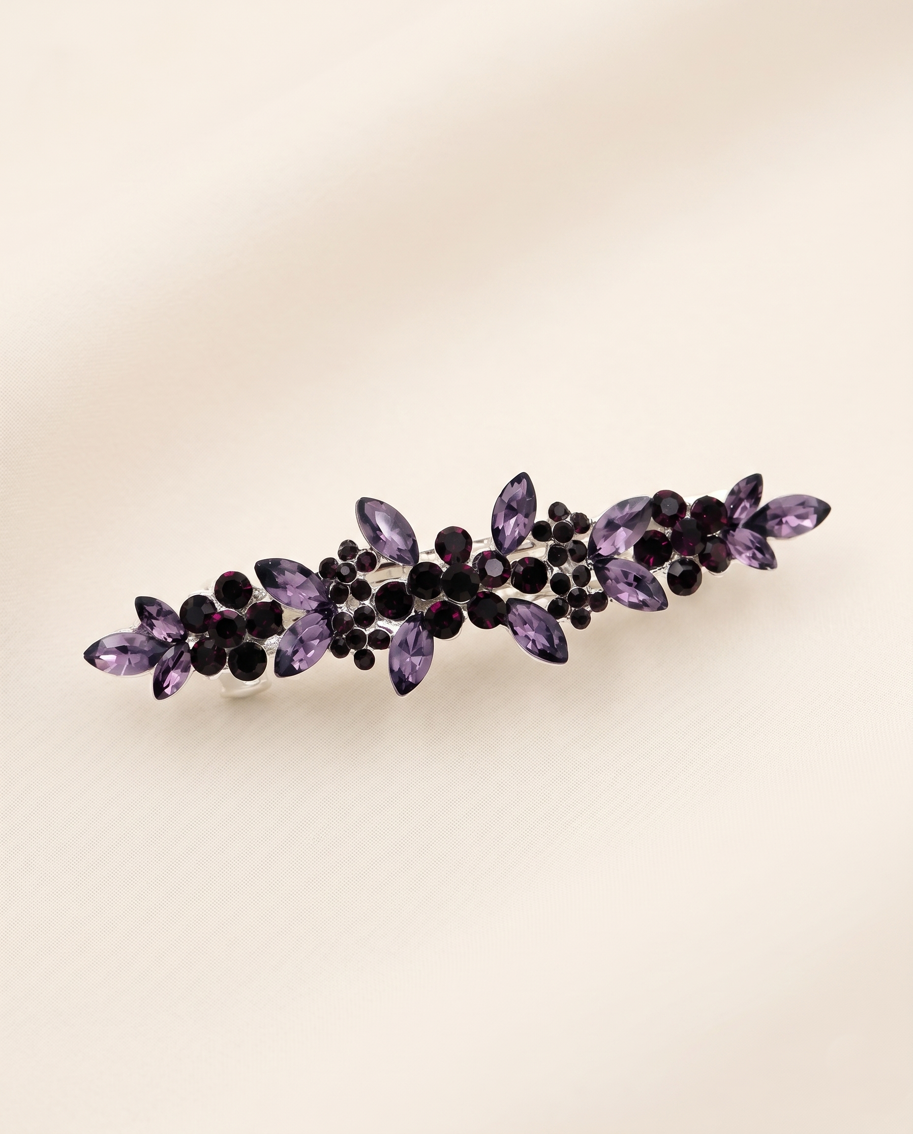 A decorative hair clip adorned with purple gemstones.
