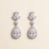 A pair of elegant earrings with large, clear gemstones set in a halo-like design.
