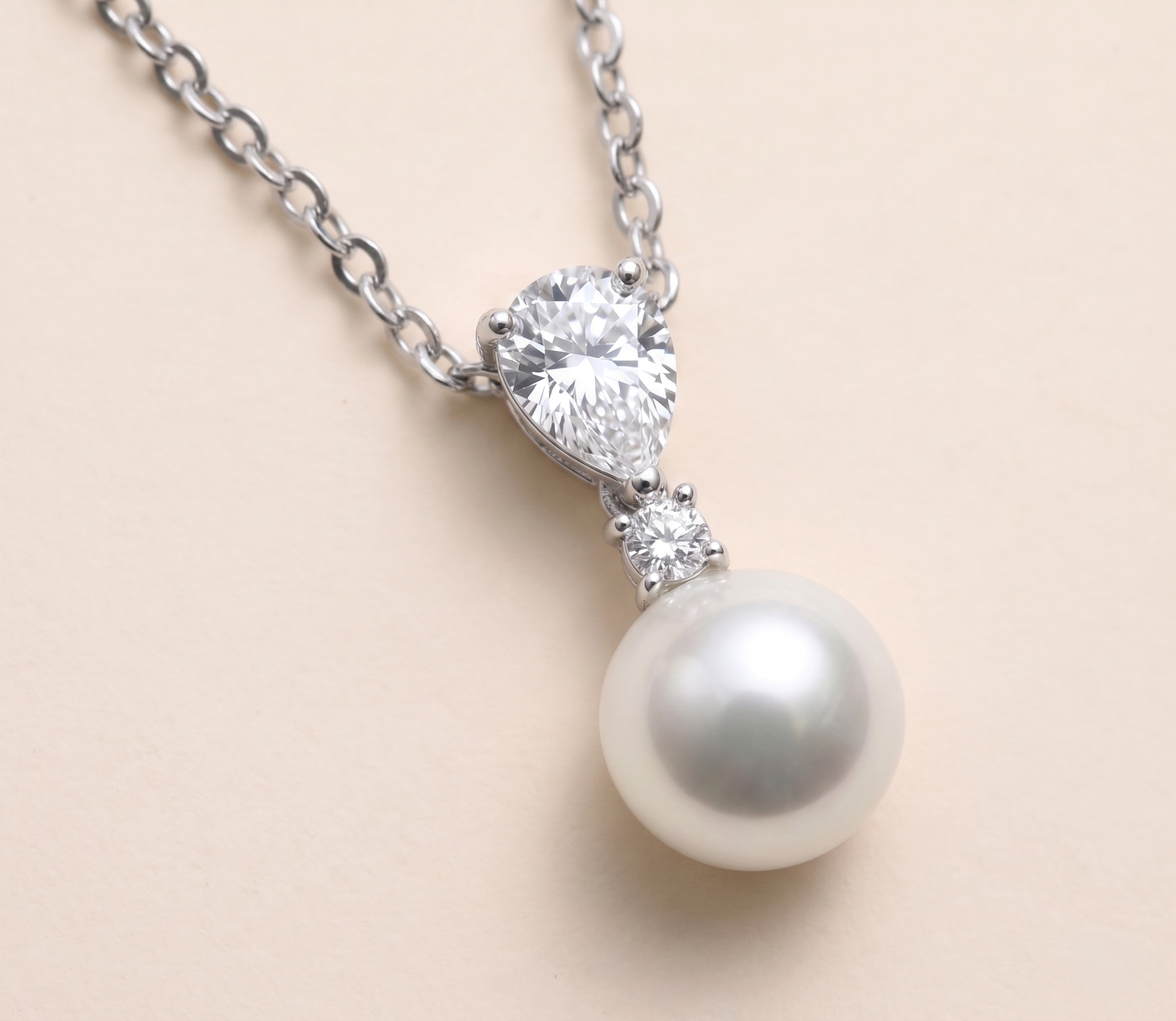 A necklace with a pearl pendant and a large diamond set in the center.