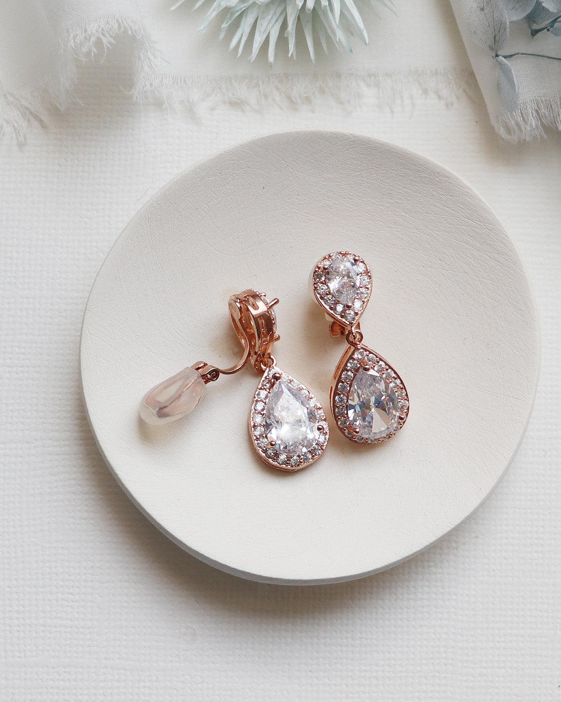 a pair of earrings sitting on top of a white plate