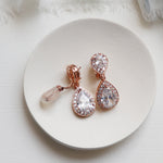 a pair of earrings sitting on top of a white plate