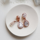 a pair of earrings sitting on top of a white plate