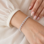 A close-up view of a person's wrist wearing a delicate bracelet adorned with small diamonds.