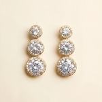 A pair of elegant gold earrings with three tiers of round, sparkling diamonds.