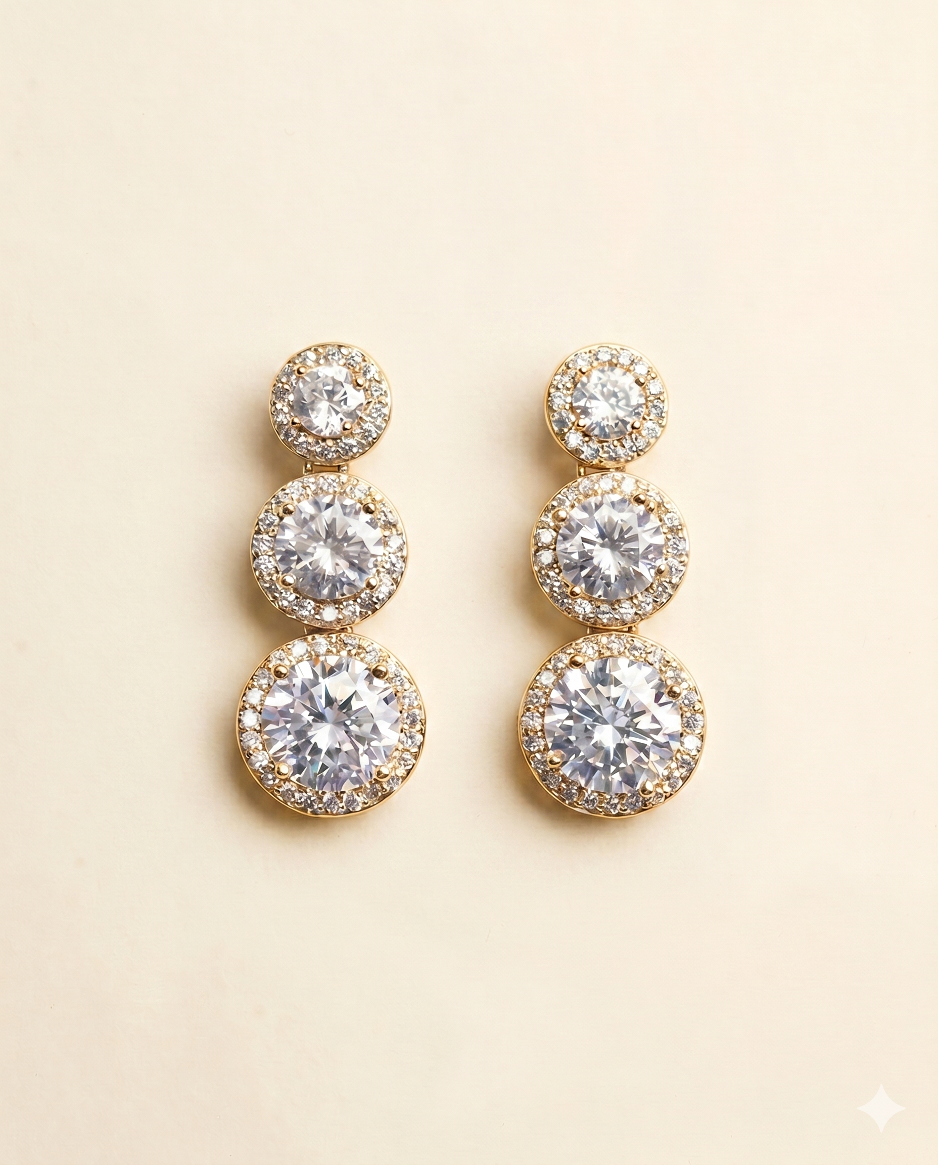 A pair of elegant gold earrings with three tiers of round, sparkling diamonds.