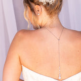 the back of a woman wearing a white strapless wedding dress with a delicate flower hair accessory.