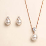 A necklace with a pendant and earrings made of pearls and diamonds.