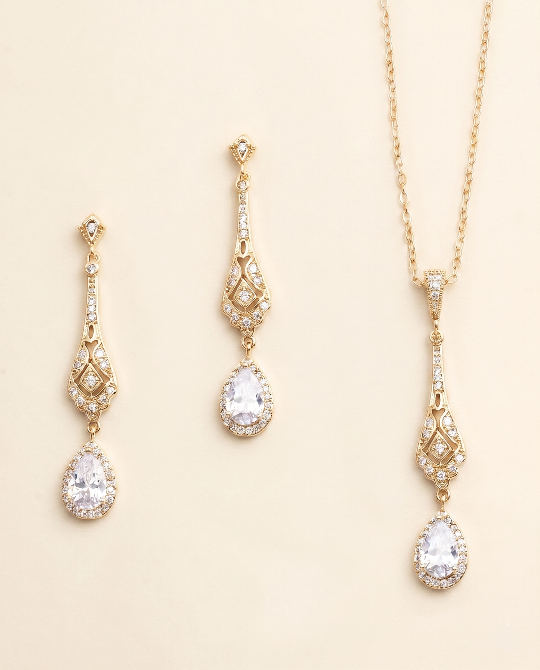 A set of three gold-colored jewelry pieces, including earrings and a necklace, with clear gemstones.