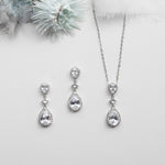 a necklace, earrings and a flower on a white background