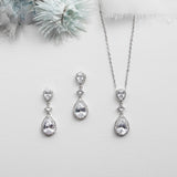 a necklace, earrings and a flower on a white background